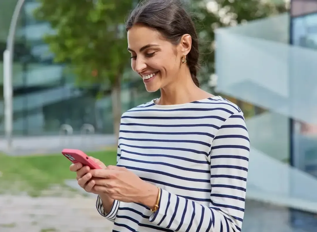 Mulher sorridente a consultar o telemóvel
